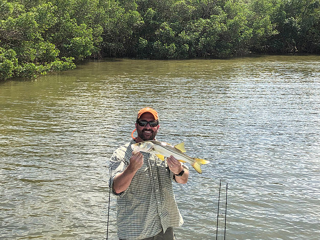 An angler holds a snook caught in the potholes of the flats 