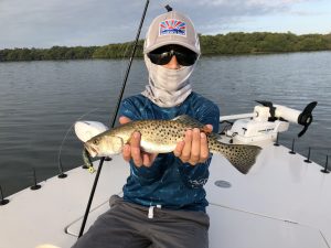 A young angler holding a speckled seatrout