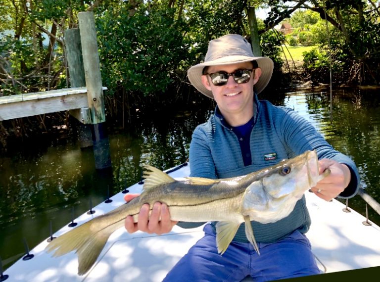 An angler holds a snook caught in the winter