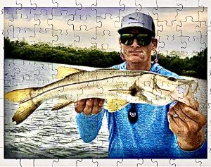 The author holds a snook with a puzzle filter over the picture
