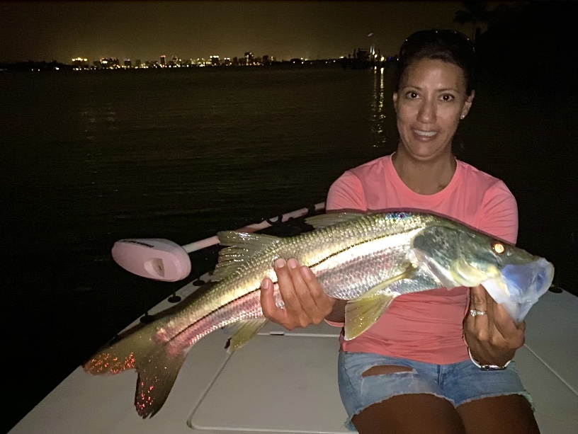An angler holds up a snook for the camera
