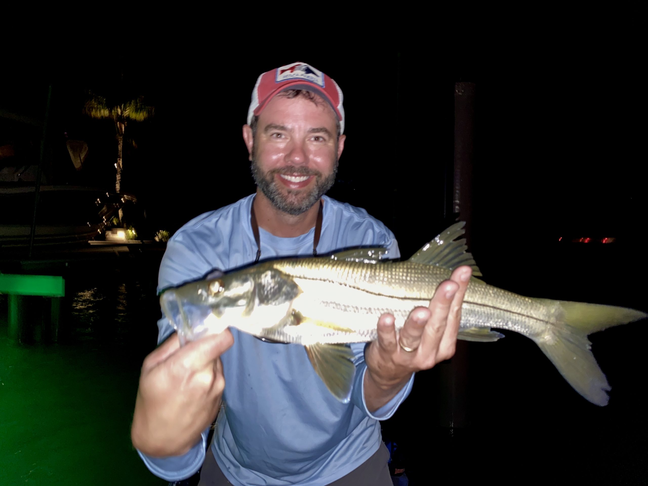 An angler holds a snook caught while fly fishing in Sarasota, FL