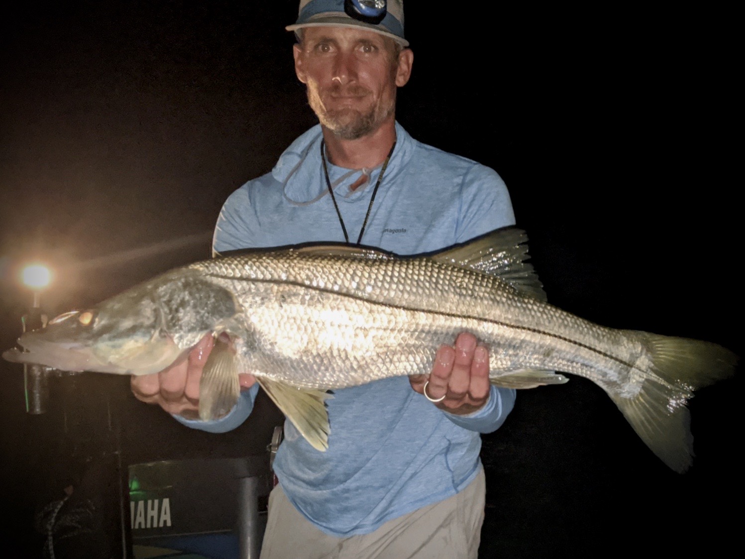 The author holds a solid snook up to the camera