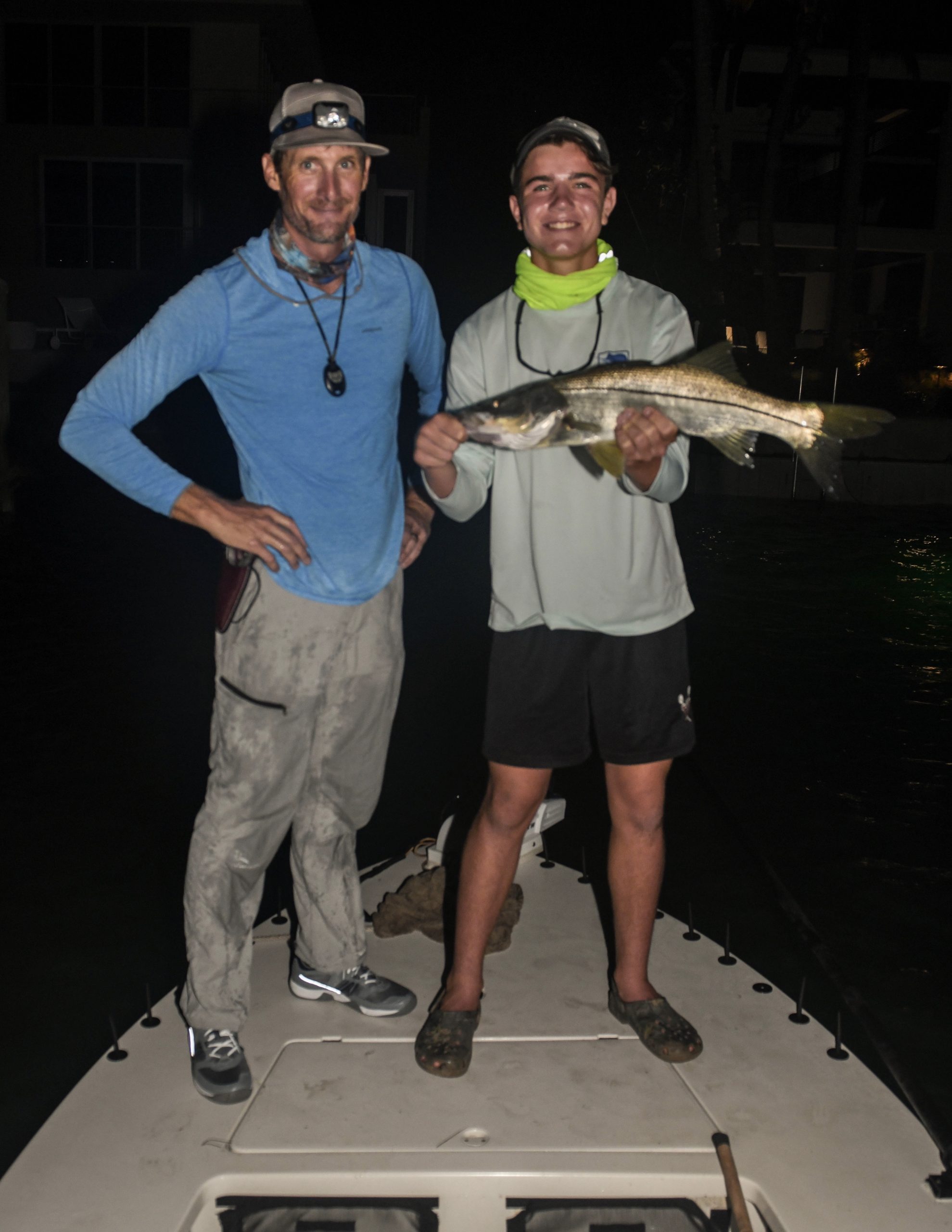The author stands next to a fine young angler holding a snook