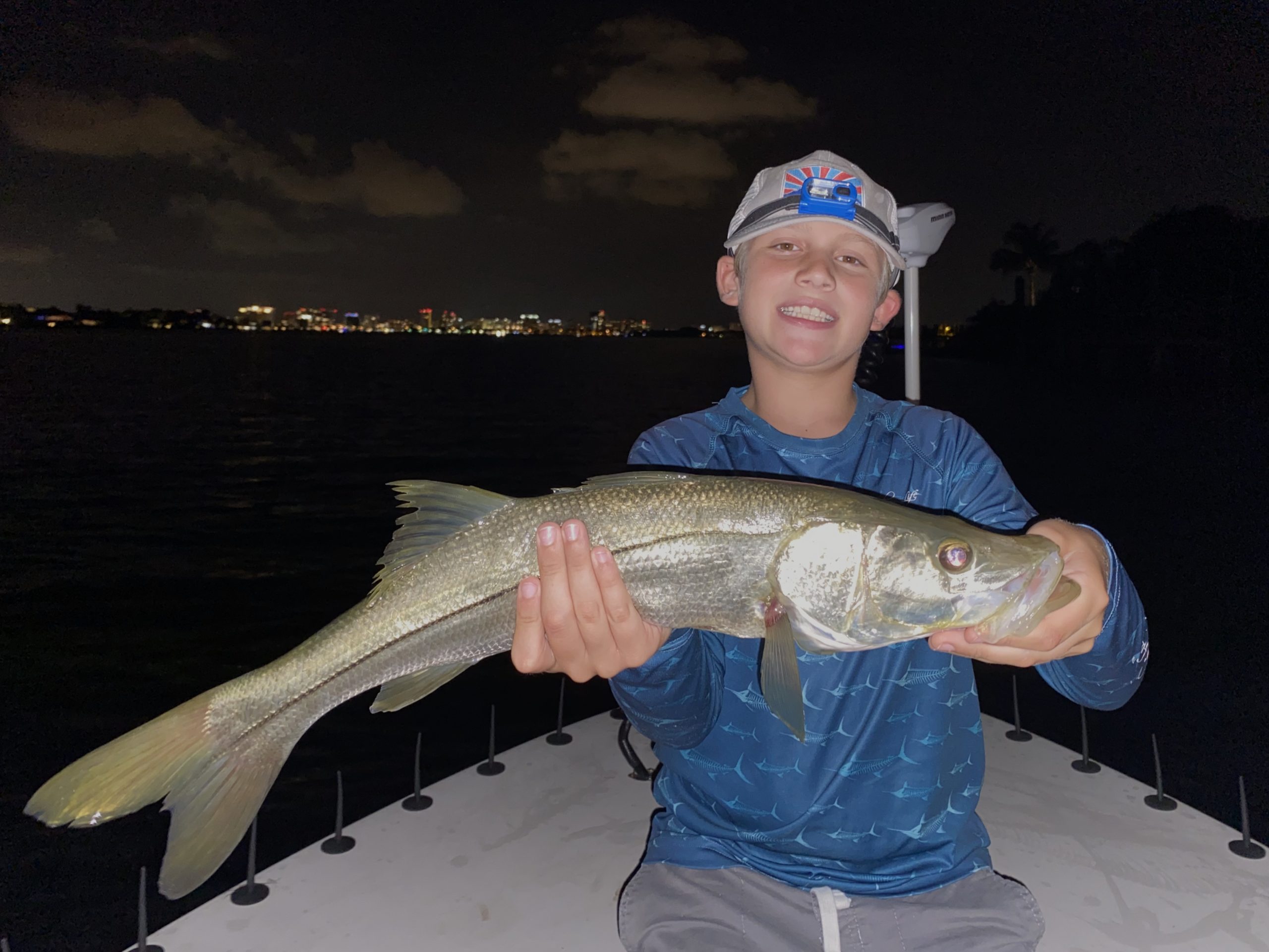 A young angler holds a snook up for the camera
