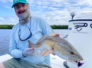 Angler holds a redfish he caught on fly