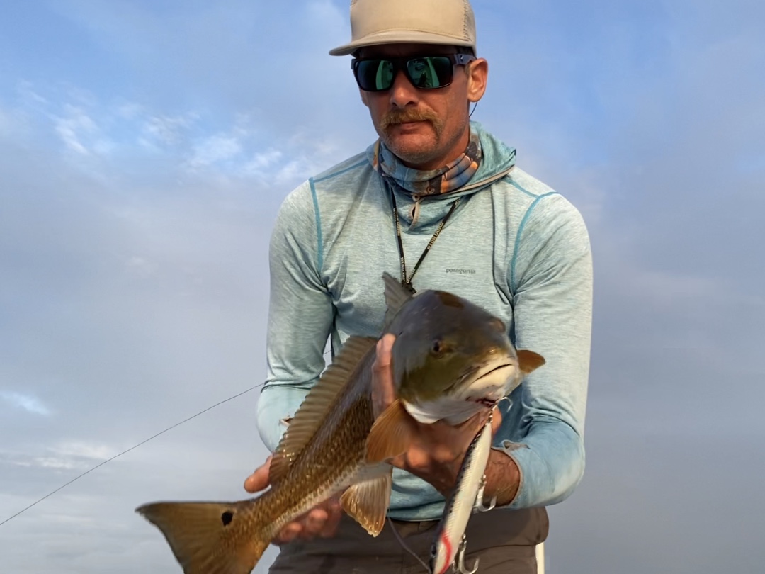 Captain Brian holds a redfish for the camera