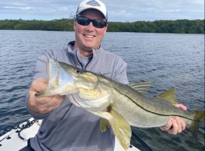 Angler holds snook he caught on fishing charter