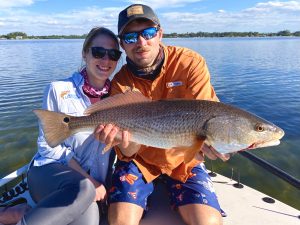 Two anglers hold a redfish