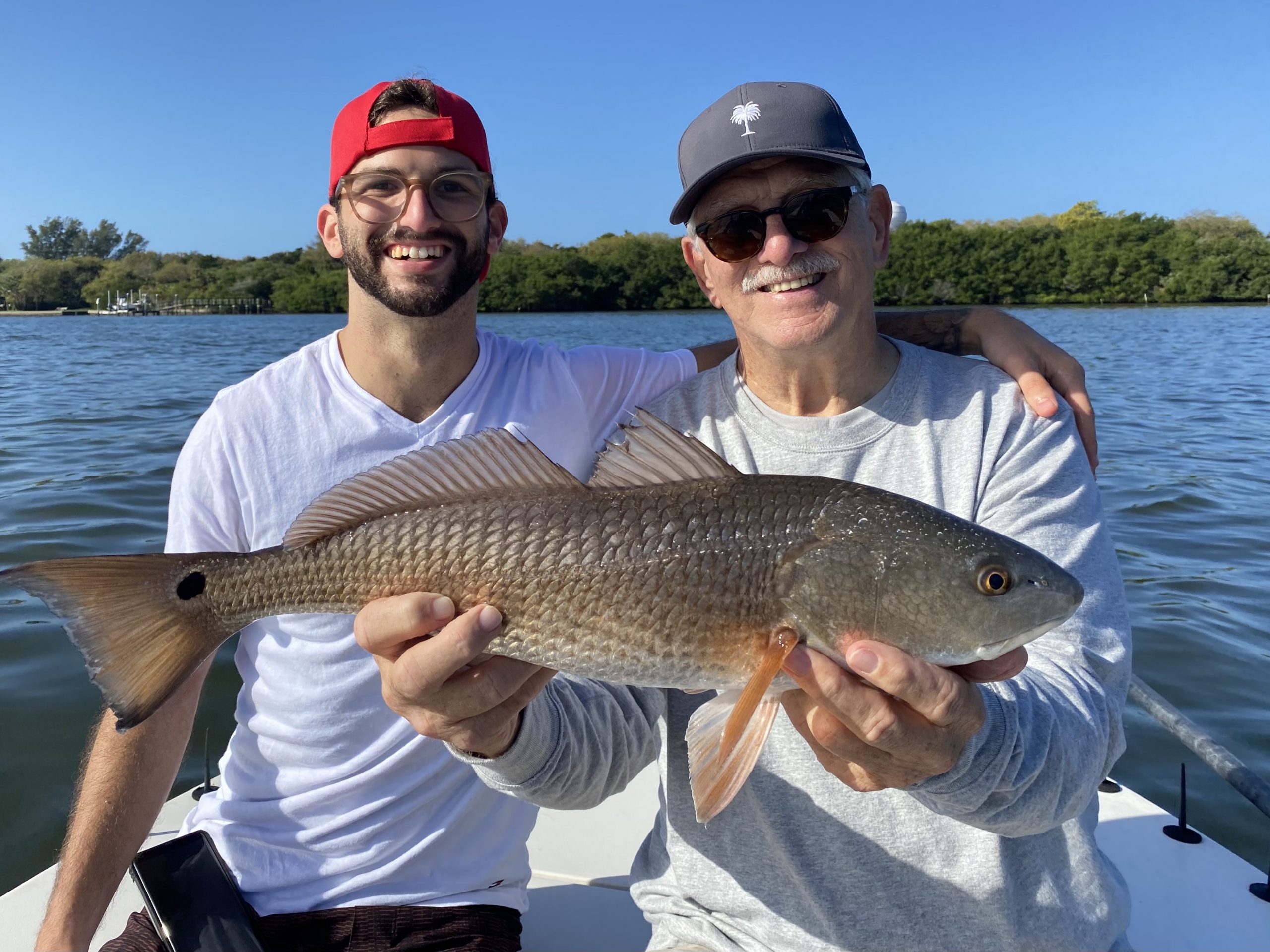 A father and son enjoy a redfish caught in Sarasota