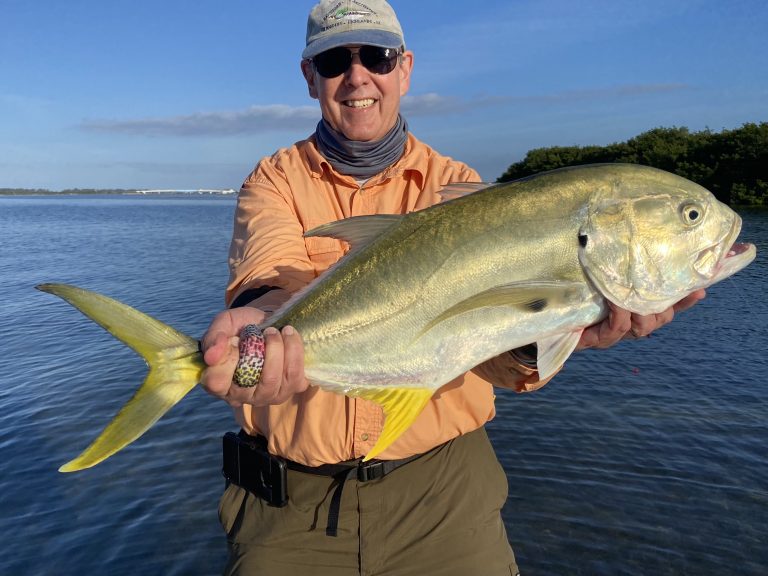 An angler holds a giant jack crevalle up for the camera