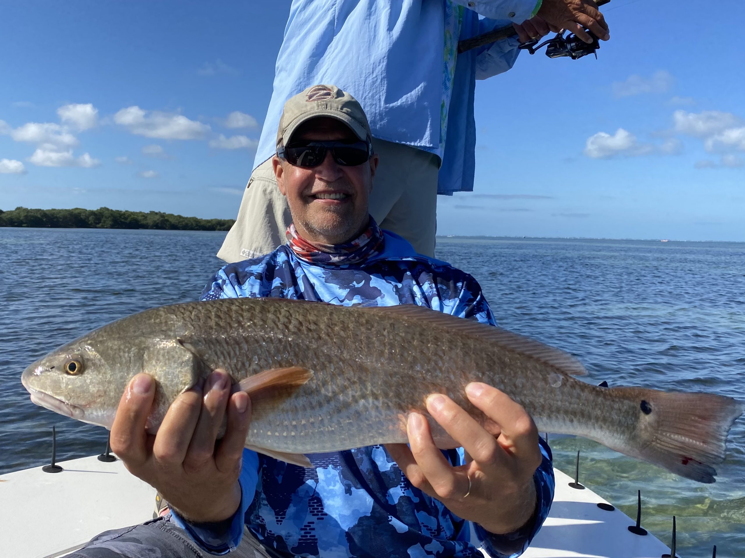 An angler holds a redfish he caught on a fishing charter in lower tampa bay