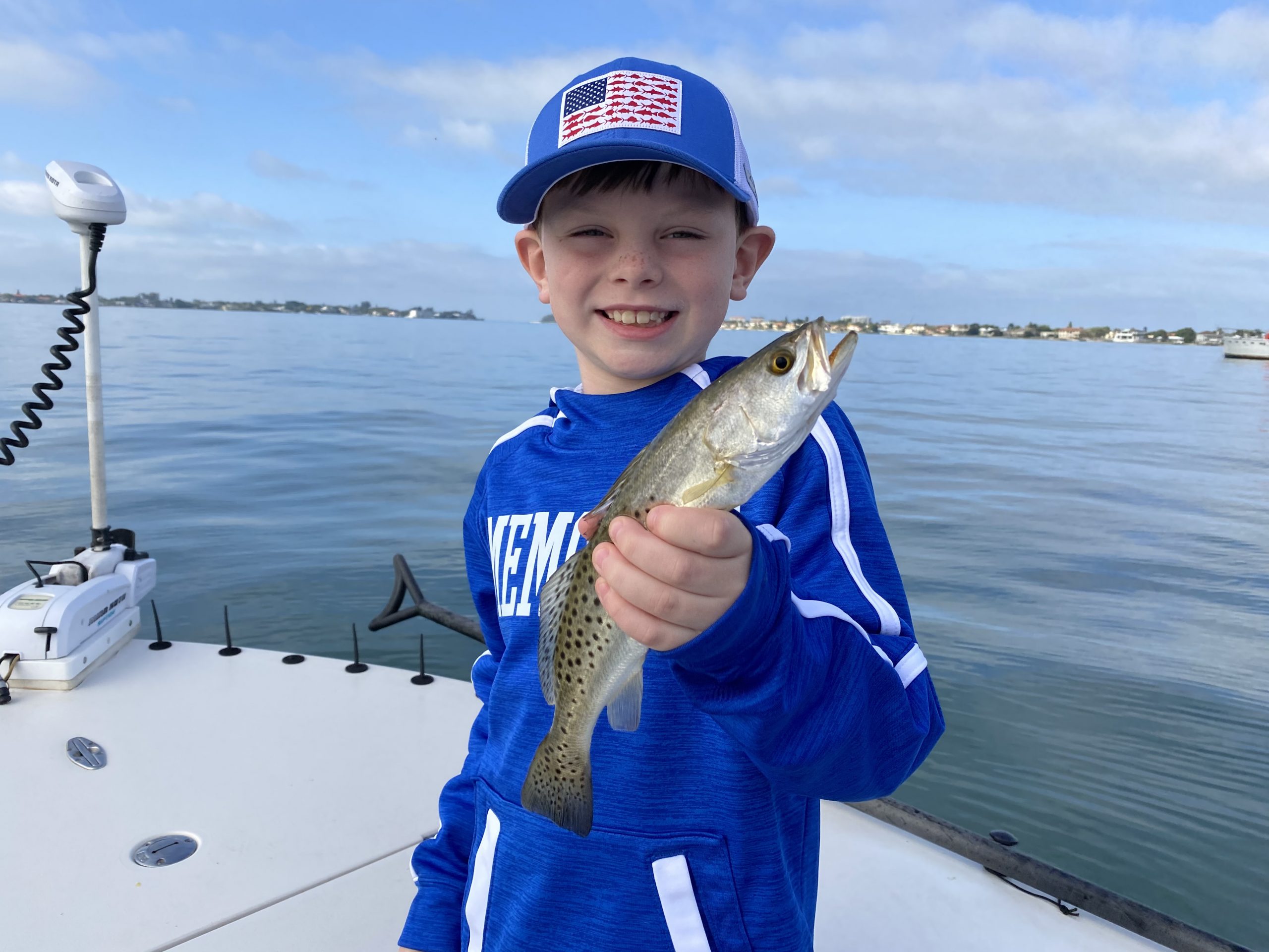 A young angler holds a seatrout he caught in Sarasota, FL