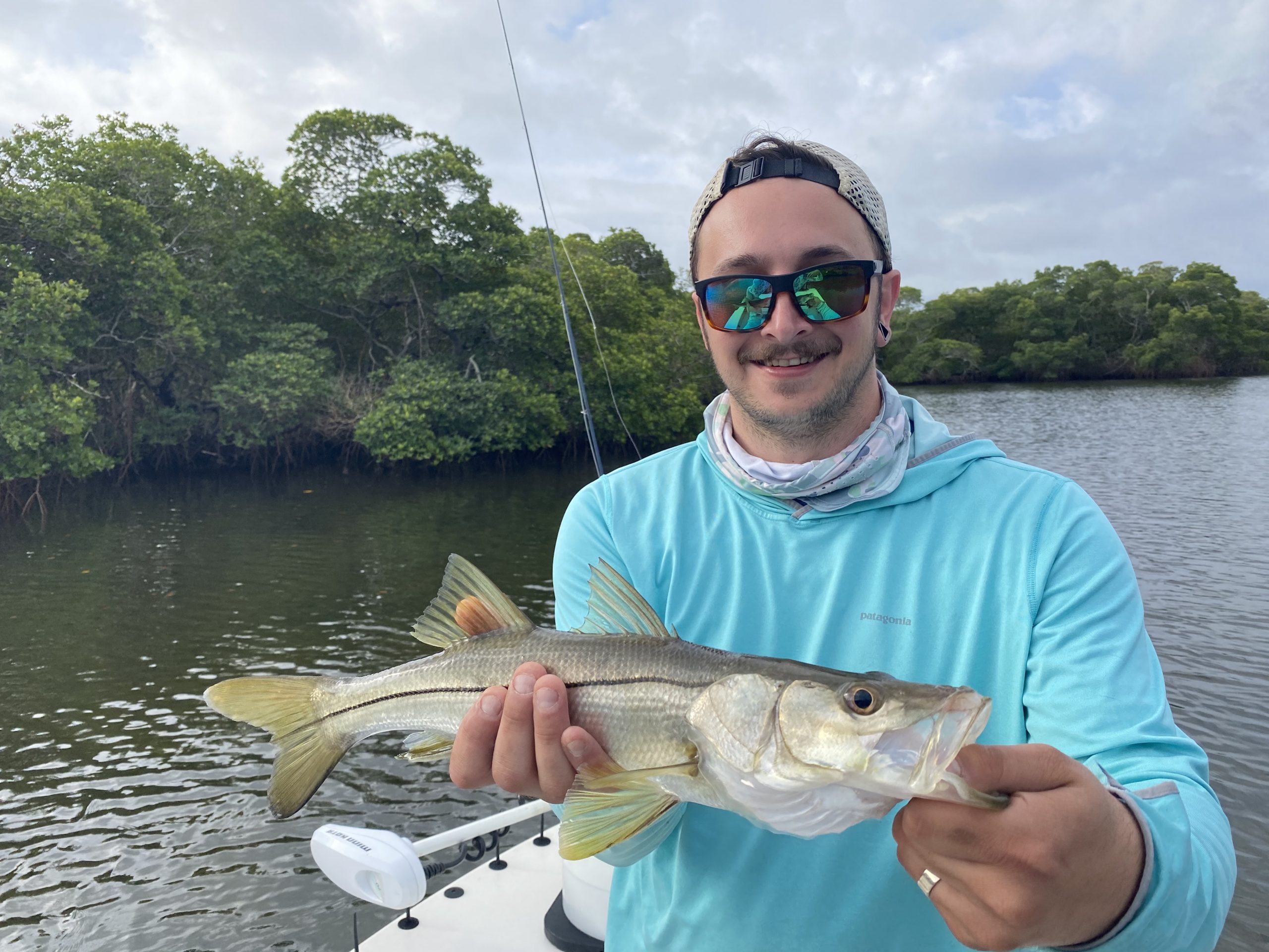 A snook is held out by an angler for the camera