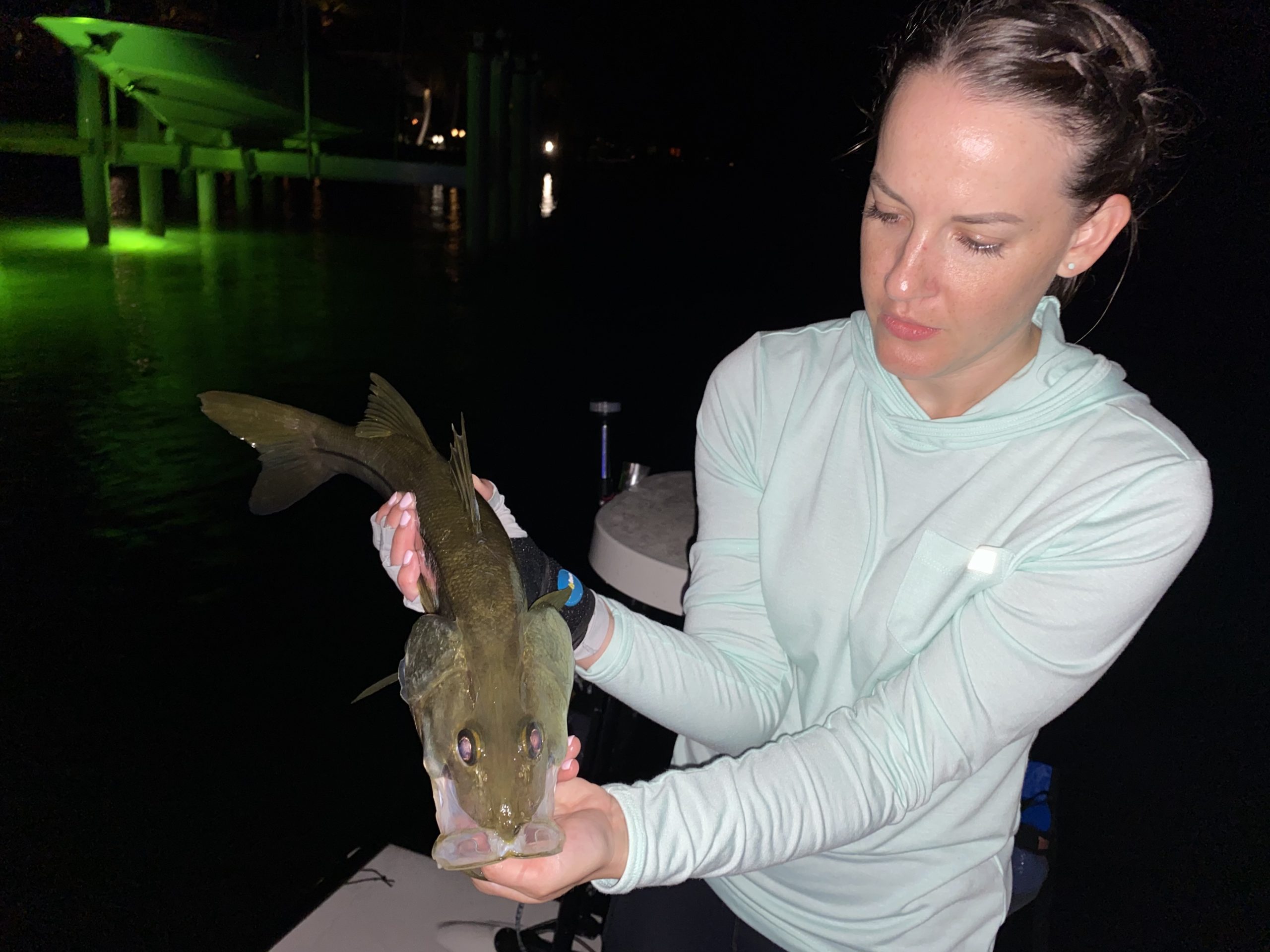 An angler holds a snook she caught with a fly