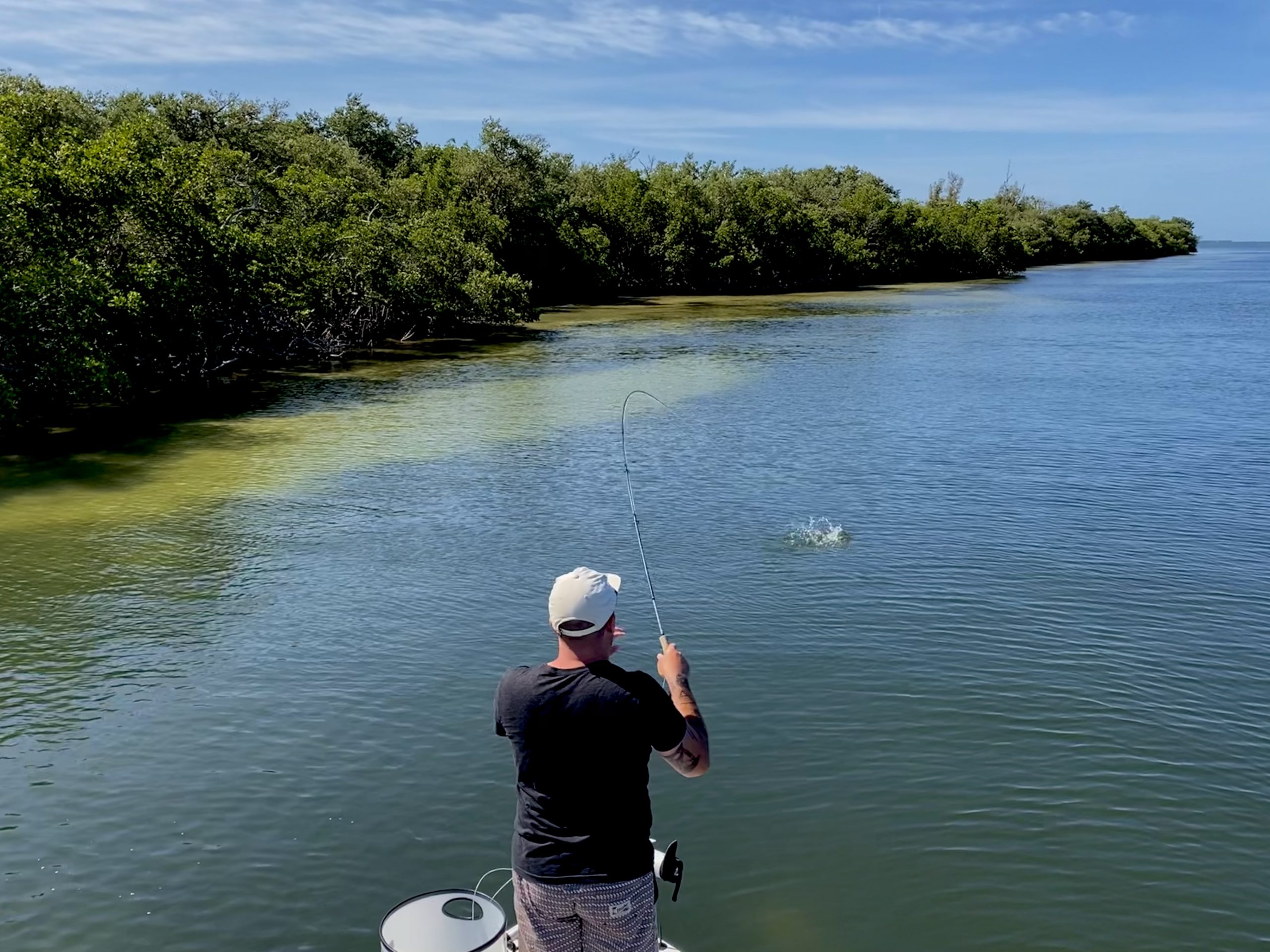 An angler fights a fish with a fly rod