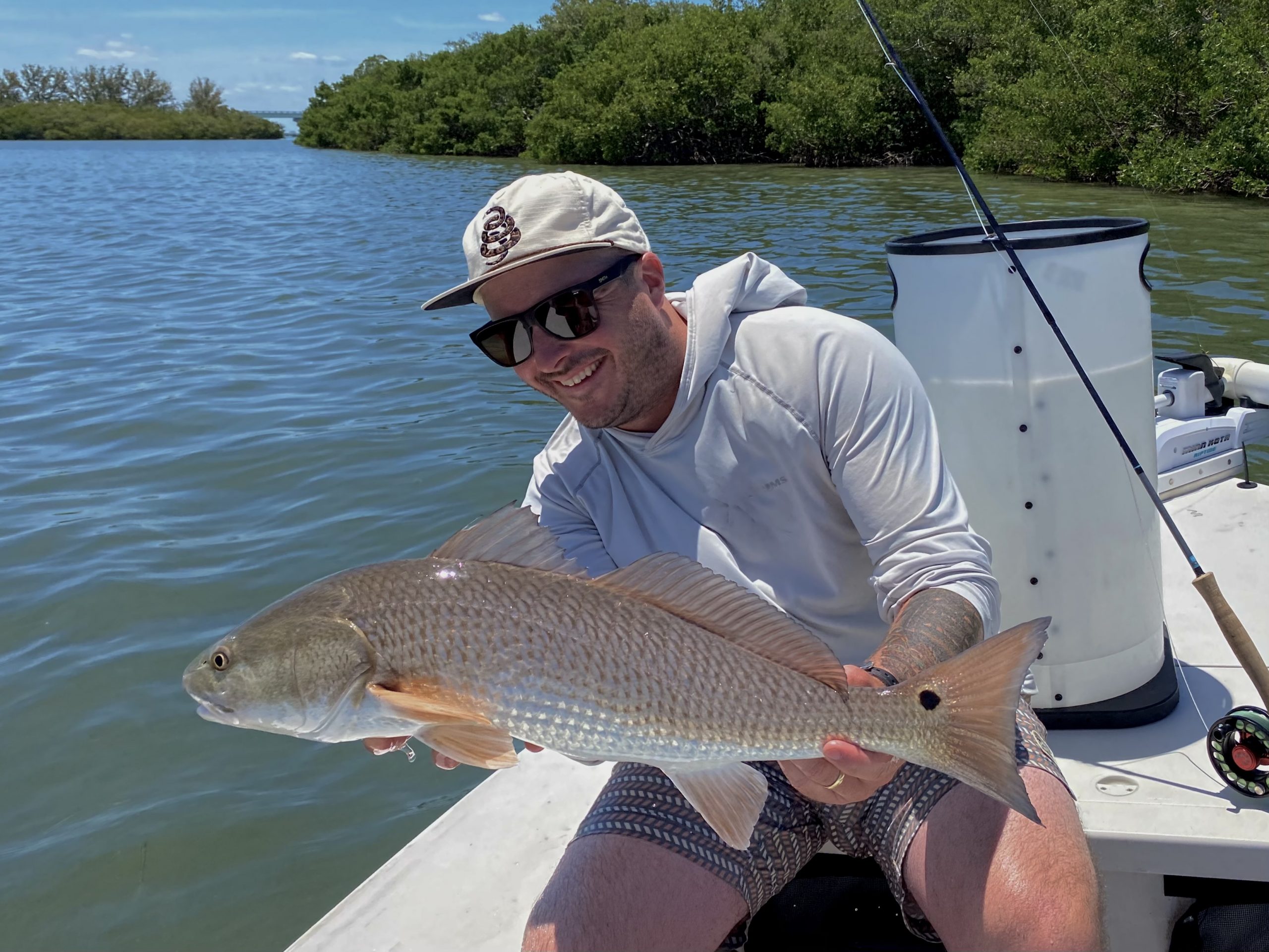 An angler smiles at the redfish he caught