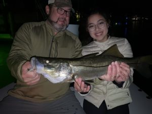 A father and daughter hold a snook caught with a fly rod
