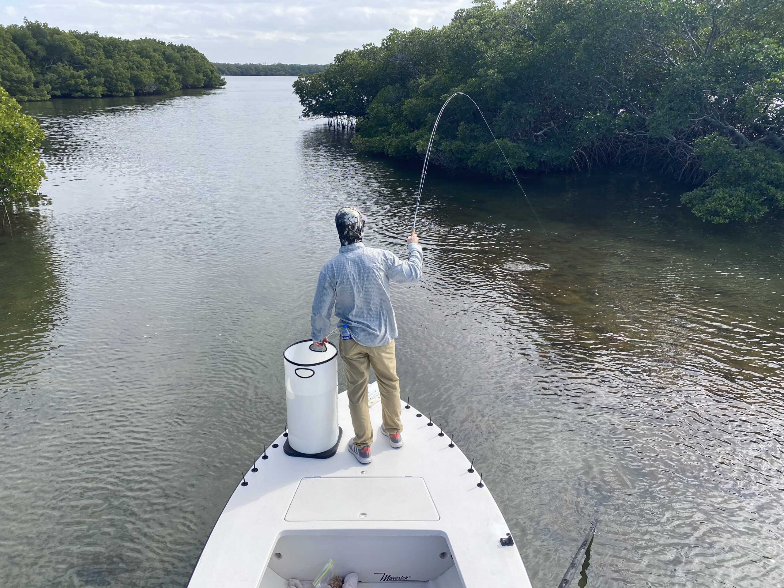 An angler fights a snook on a fly rod near mangrove islands