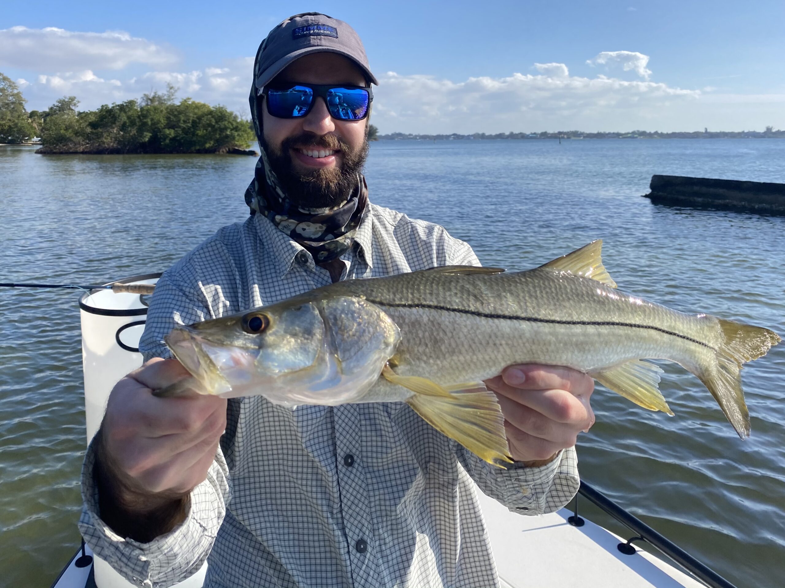 An angler holds a snook that he caught while fly fishing in Bradenton