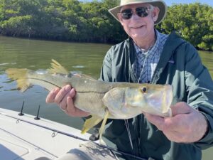 An angler holds a snook for the camera