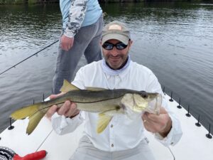 An angler holds out a snook for the camera