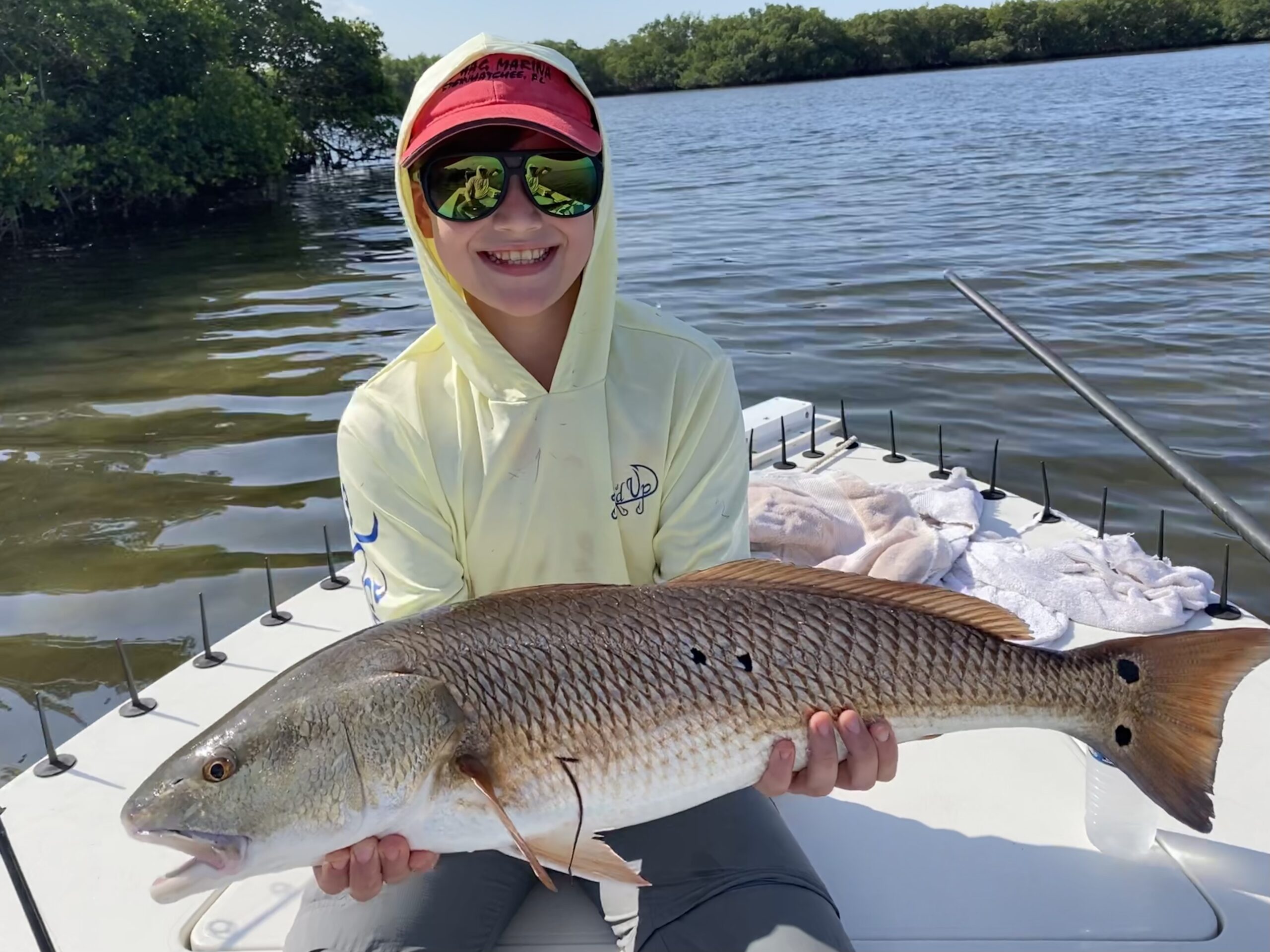 A young angler holds a nice redfish up for the camera