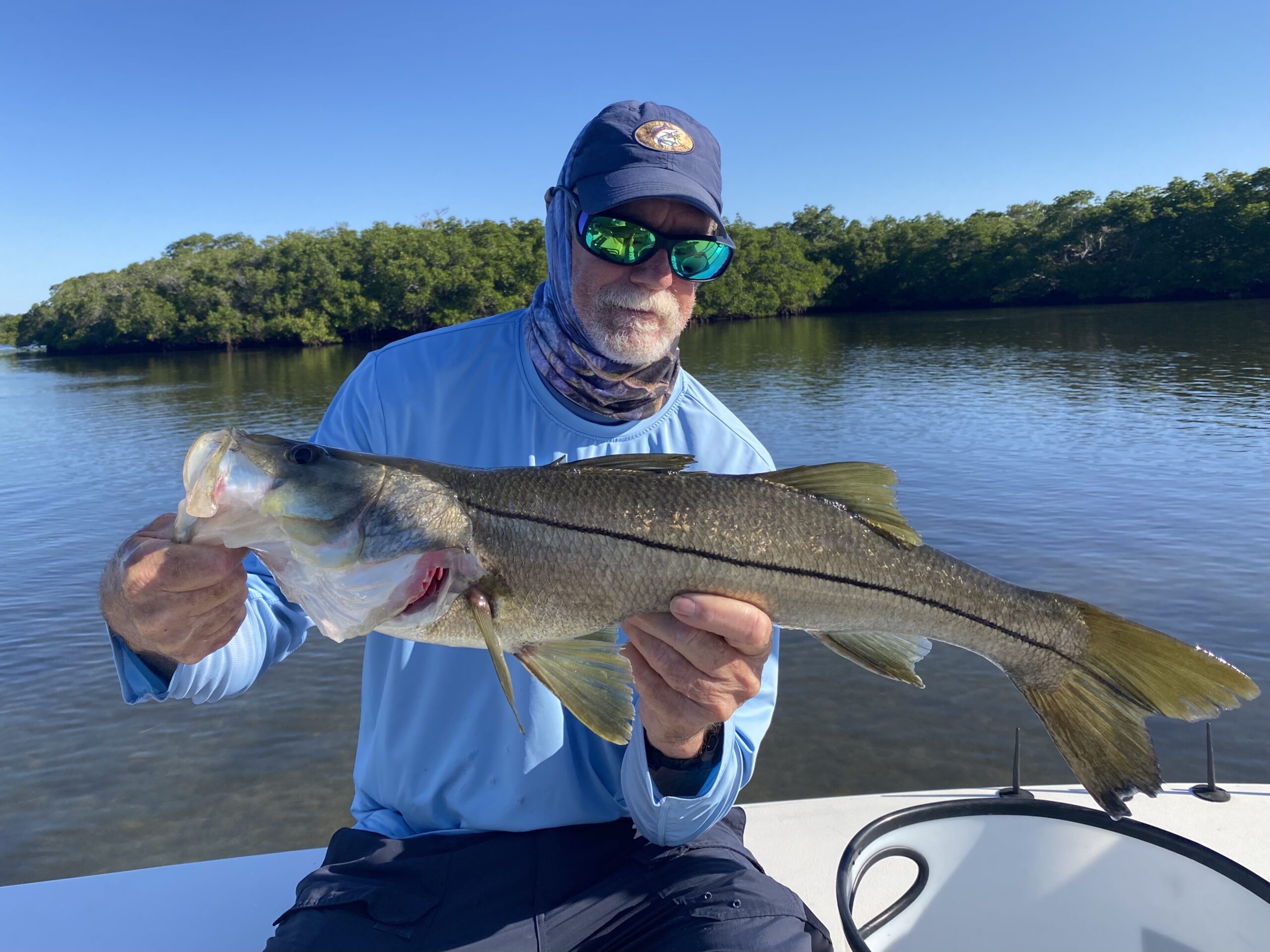 An angler holds a nice snook that he caught while fishing