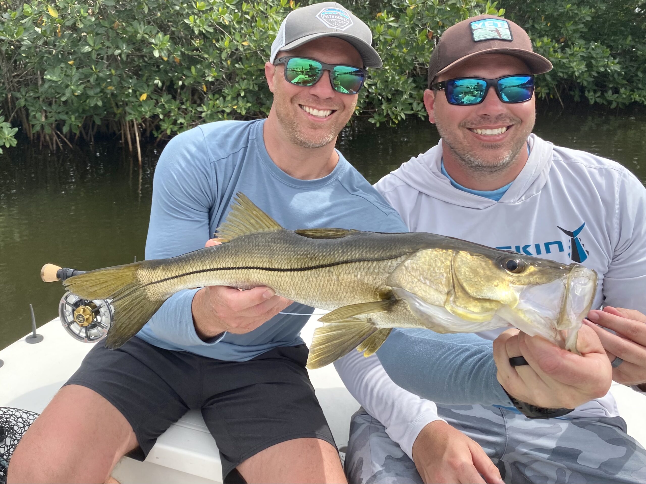 Two anglers hold up a snook they caught while on a fishing charter with Captain Brian Boehm