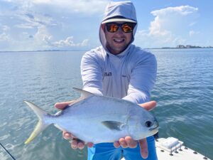 An angler holds a pompano caught in Sarasota, FL out to the camera