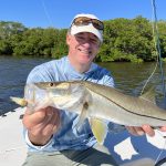 A happy angler holds out a snook for the camera.