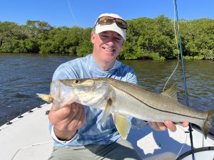 A happy angler holds out a snook for the camera.