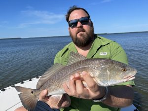 An angler holds a redfish that he caught while fishing the flats in Florida