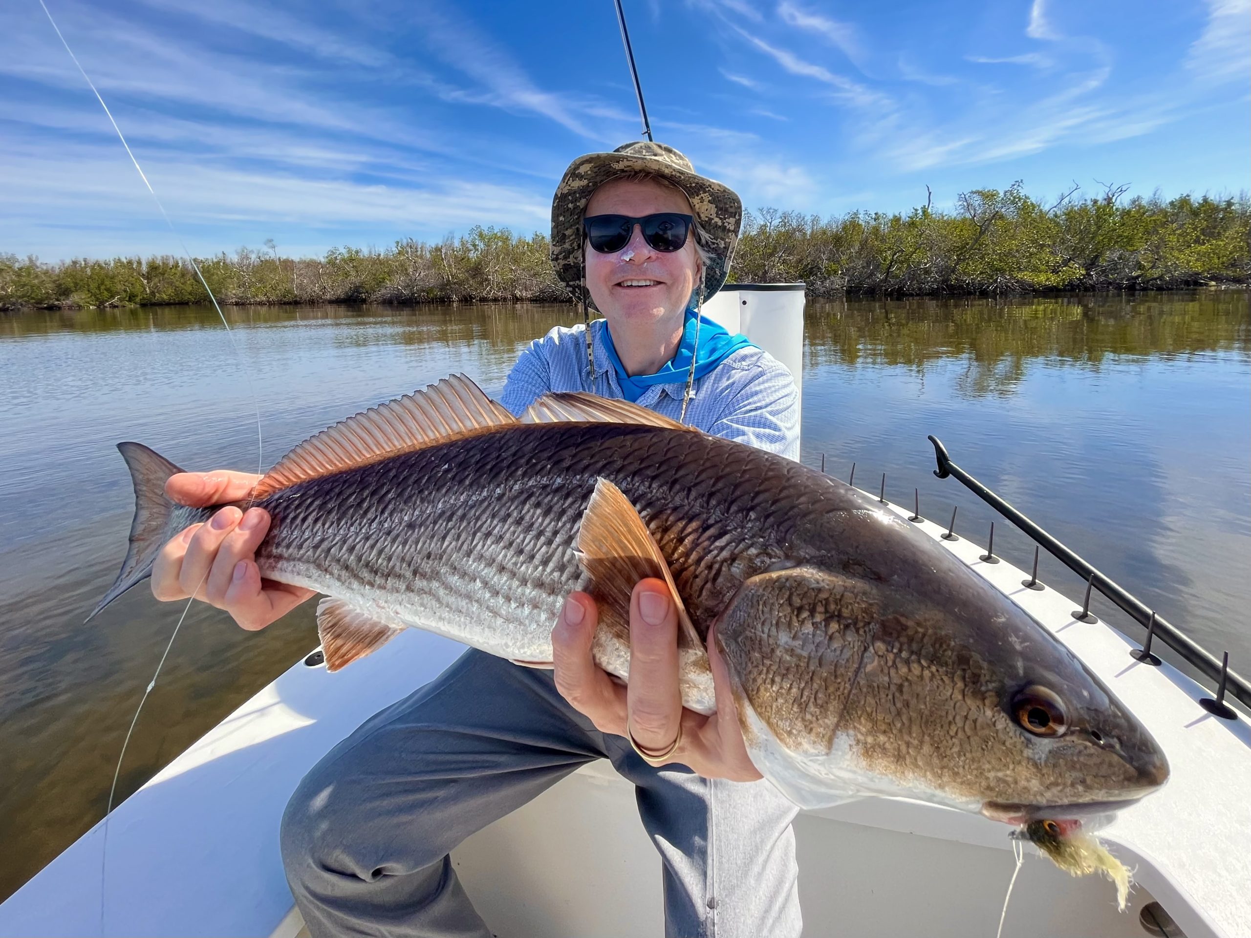 An angler holds up a redfish for the camera