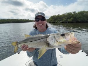 A fly angler holds a snook up for the camera