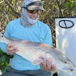 An angler smiles at the redfish that he caught while fly fishing near Sarasota, FL