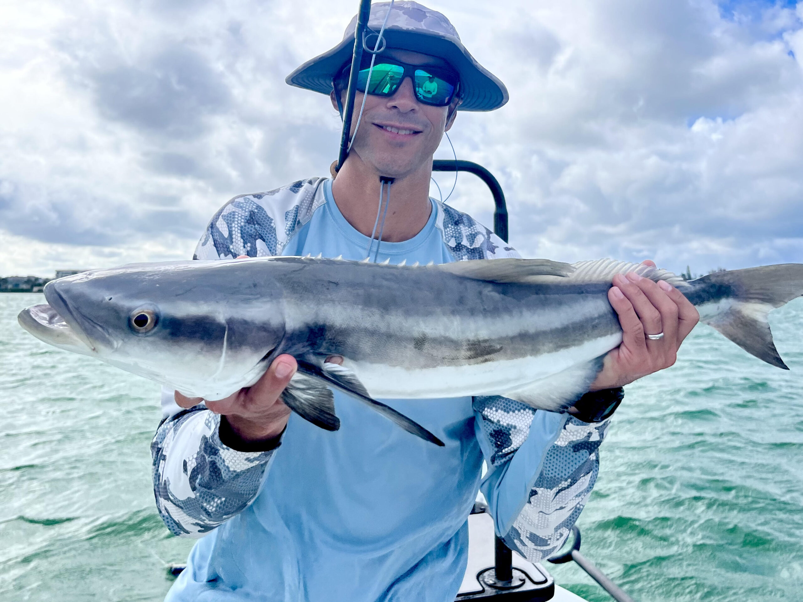 An angler holds a cobia that was caught while fly fishing for tarpon in Sarasota, FL