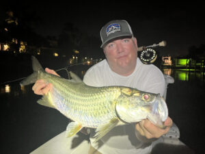 An angler holds up a tarpon that he caught while fly fishing in Sarasota, FL