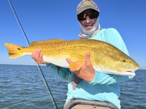 An angler holds a bull redfish