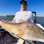 An angler holds a giant redfish